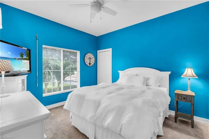 Carpeted bedroom featuring ceiling fan