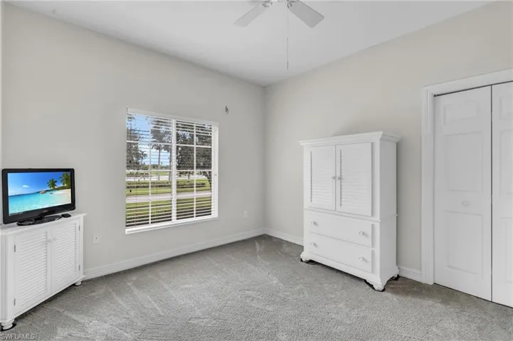Unfurnished bedroom featuring a closet, light colored carpet, and ceiling fan