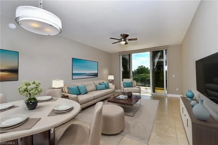 Living room with ceiling fan, impact glass sliders and tile floors
