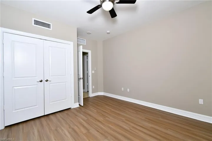 Unfurnished bedroom featuring hardwood / wood-style flooring, a closet, and ceiling fan