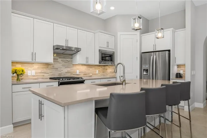 This kitchen is a chef's dream with stainless steel appliances, a beautiful backsplash, natural gas, and quartz countertops.