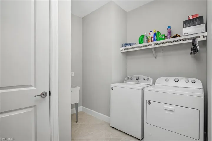 Spacious laundry area with extra shelving for storage.