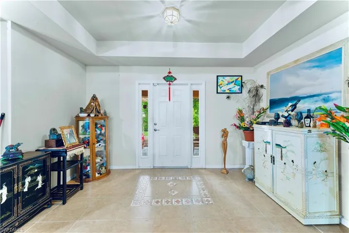 Entrance foyer with a raised ceiling and tile patterned floors