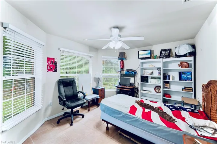 Tiled bedroom featuring baseboards and ceiling fan