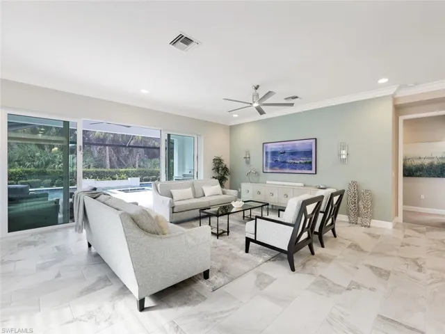 Living room featuring ceiling fan and crown molding