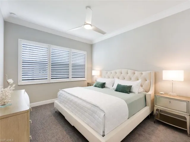 Bedroom featuring dark colored carpet, ceiling fan, and crown molding