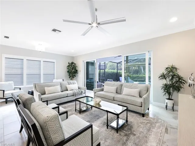Living room featuring ceiling fan and ornamental molding