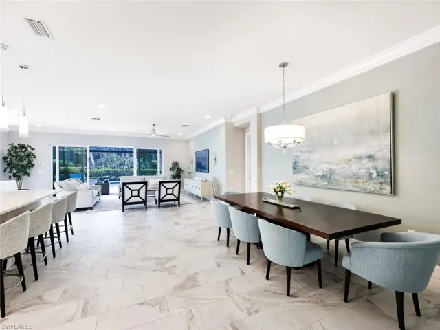 Dining space with crown molding and ceiling fan with notable chandelier