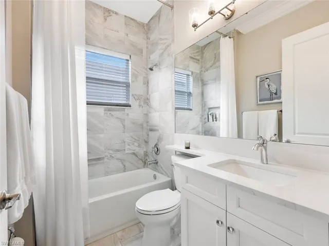 Full bathroom with shower / bath combo, toilet, crown molding, and vanity