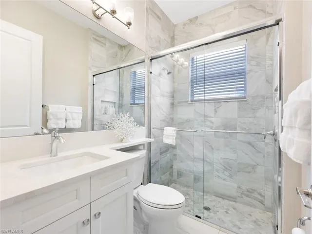Bathroom with vanity, toilet, and an enclosed shower