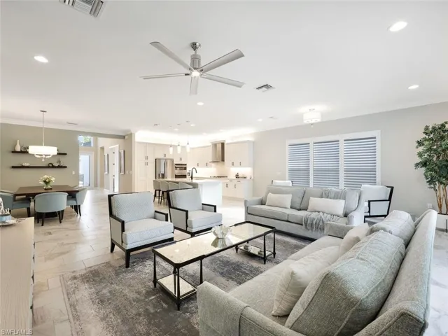 Living room featuring ceiling fan, sink, and crown molding