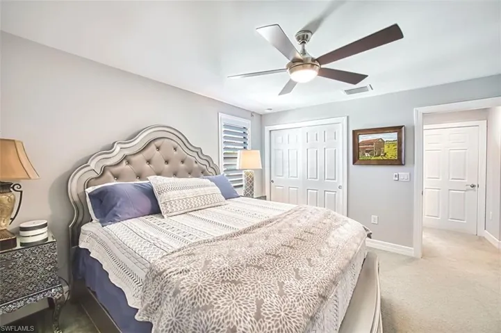 Carpeted bedroom featuring a closet and a ceiling fan