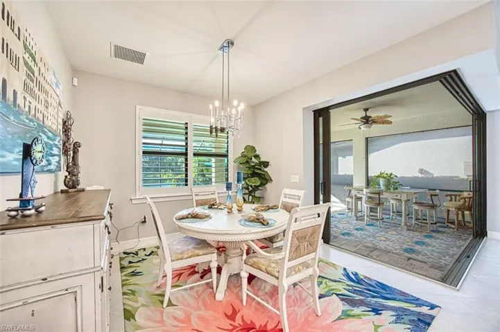 Dining room with a chandelier, ceiling fan, and light tile patterned flooring