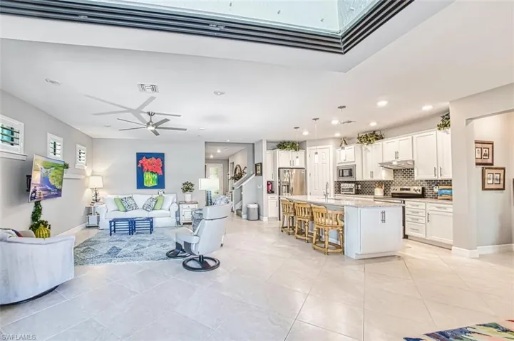 Living room with ceiling fan, recessed lighting, and light tile patterned floors