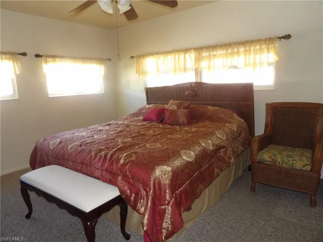 Carpeted bedroom featuring a ceiling fan