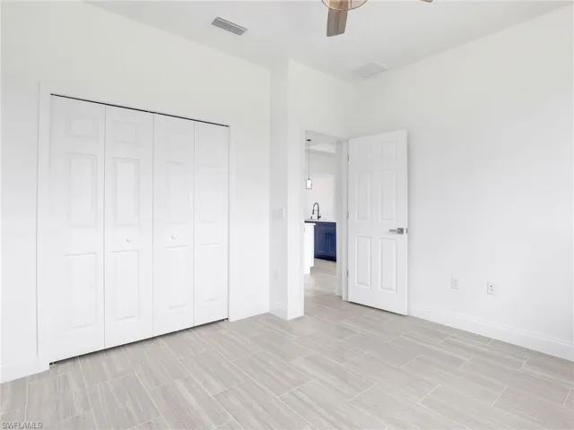 Unfurnished bedroom featuring a closet, ceiling fan, and light tile floors