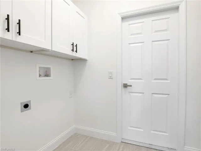 Clothes washing area featuring electric dryer hookup, cabinets, and washer hookup