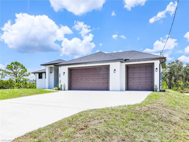 View of front of house with a front yard and a garage
