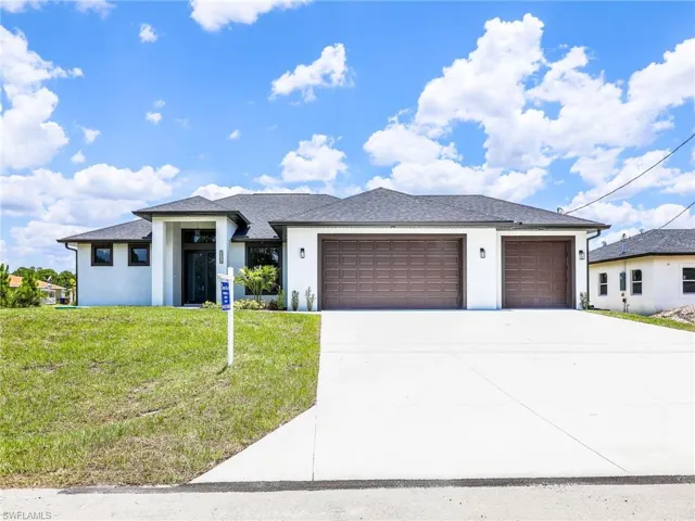 View of front of house with a garage and a front lawn