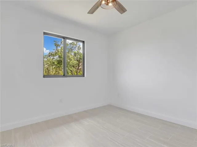 Tiled empty room featuring ceiling fan