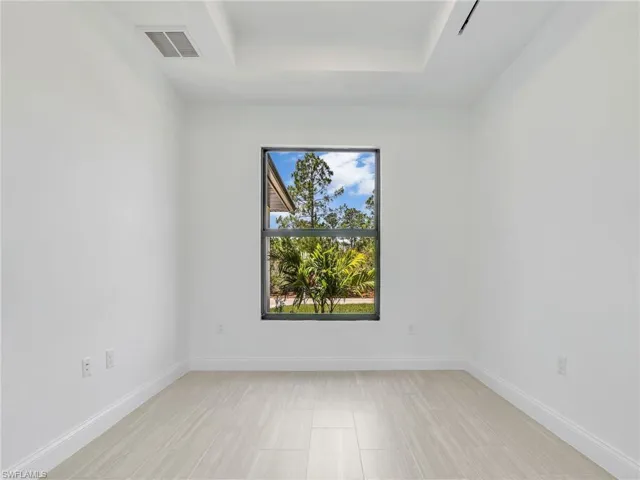Unfurnished room with a tray ceiling