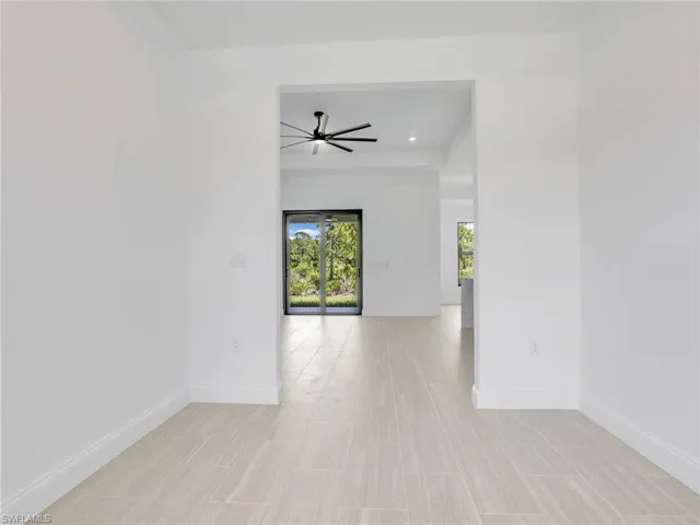Den with ceiling fan and light tile floors