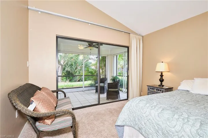 Bedroom with lofted ceiling, access to outside, and carpet flooring