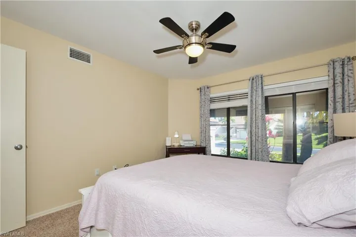 Bedroom with a ceiling fan, baseboards, visible vents, and carpet flooring