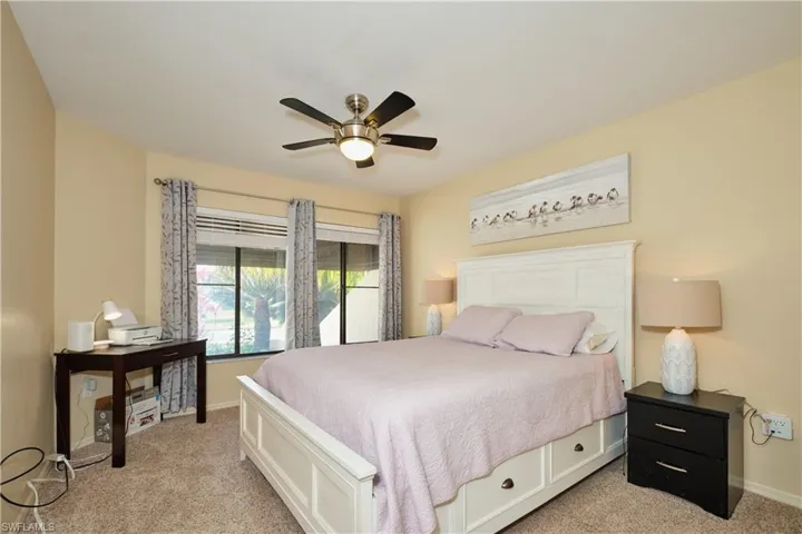 Bedroom featuring ceiling fan, baseboards, and light colored carpet