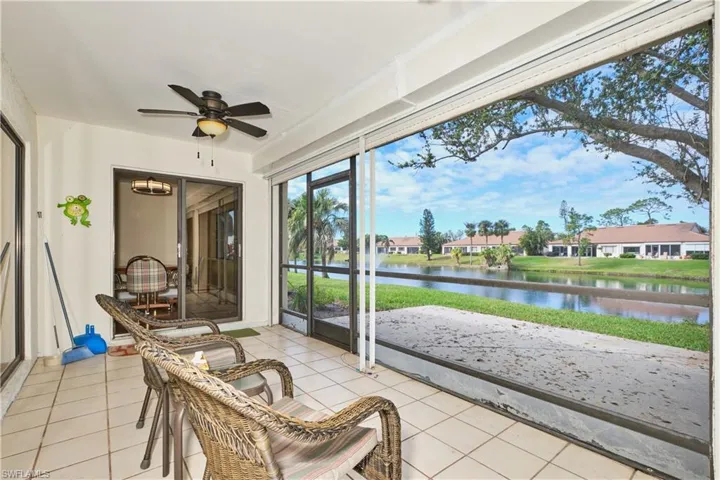 Sunroom featuring a ceiling fan and a water view