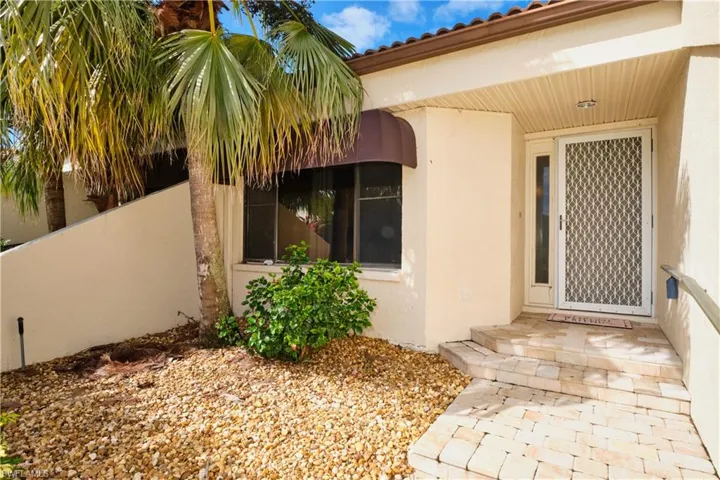 Doorway to property featuring a tiled roof and stucco siding