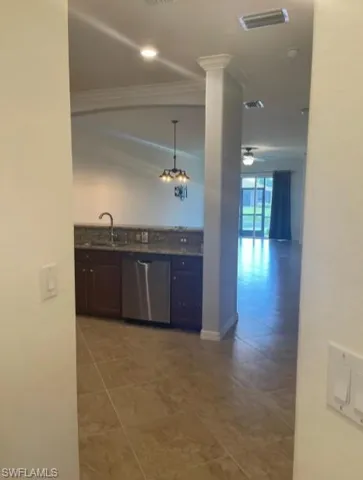 Kitchen featuring ornamental molding, visible vents, dishwasher, a sink, and tile patterned floors