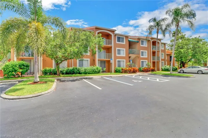 View of apartment building / complex featuring uncovered parking