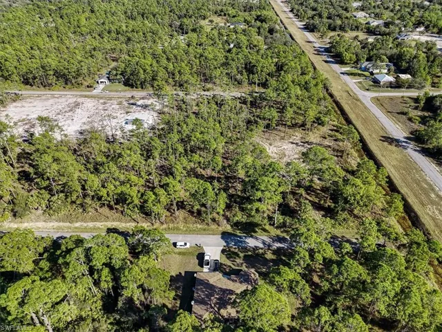 Aerial view of property and surrounding area featuring a heavily wooded area