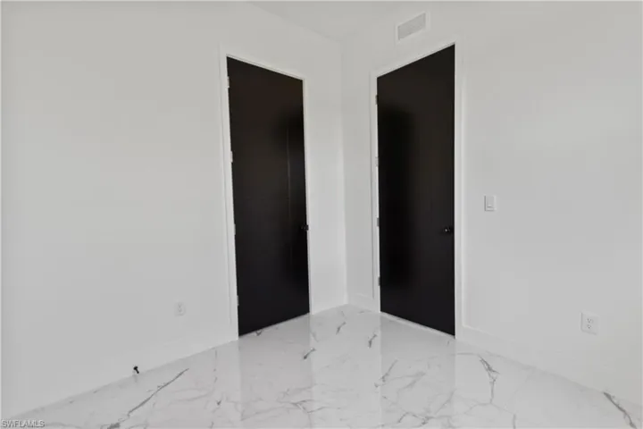 Spare room with baseboards and marble finish floors