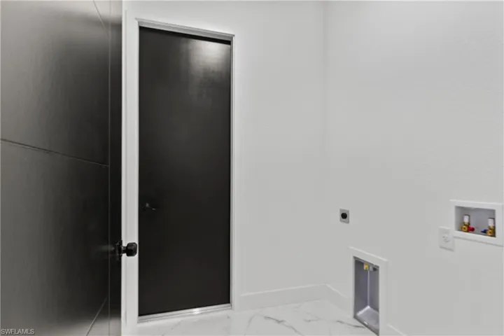 Laundry room featuring hookup for an electric dryer, light marble finish floors, and washer hookup