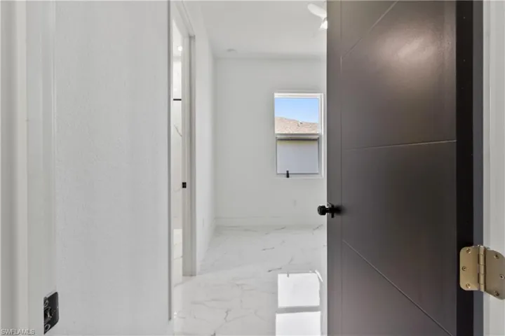 Hallway with marble finish flooring and baseboards