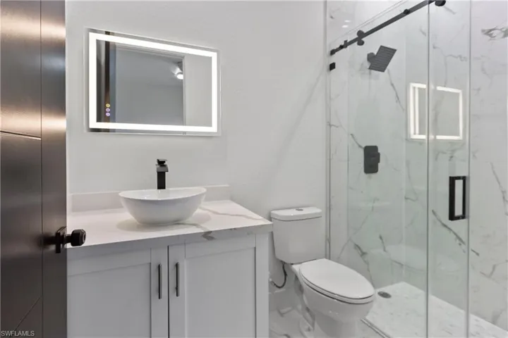 Full bathroom featuring vanity and a marble finish shower