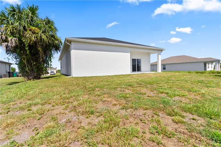 View of property exterior with stucco siding and a yard