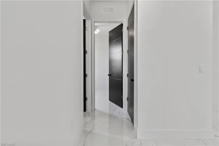 Hall with light marble finish flooring and baseboards