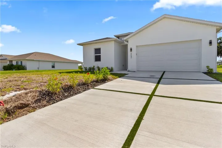 Ranch-style house featuring stucco siding, an attached garage, and concrete driveway