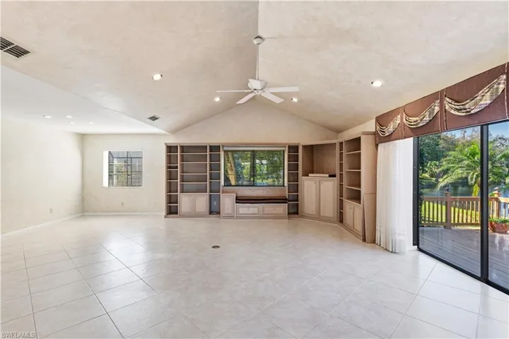 Unfurnished living room featuring ceiling fan, healthy amount of natural light, built in features, light tile patterned flooring, and recessed lighting