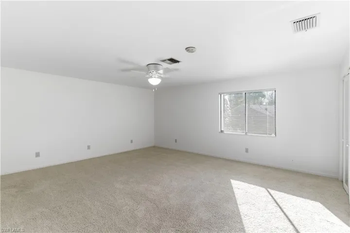 upstairs Bedroom featuring light colored carpet and a ceiling fan