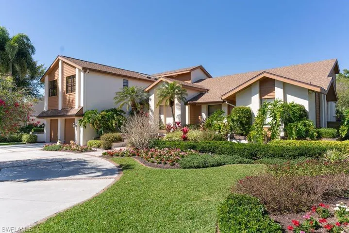 View of front of home featuring stucco siding, a garage, a front yard, and driveway