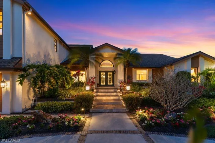 Exterior entry at dusk featuring french doors and stucco siding