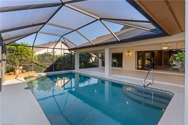 Swimming pool featuring a sunroom, a patio area, and a lanai