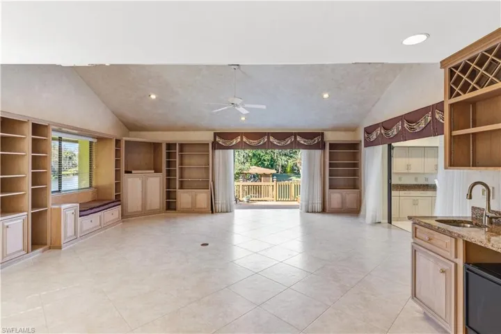 Kitchen featuring vaulted ceiling, built in features, open shelves, recessed lighting, and ceiling fan