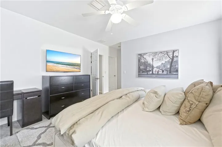 Primary bedroom with a king size bed, dresser, nightstands and TV