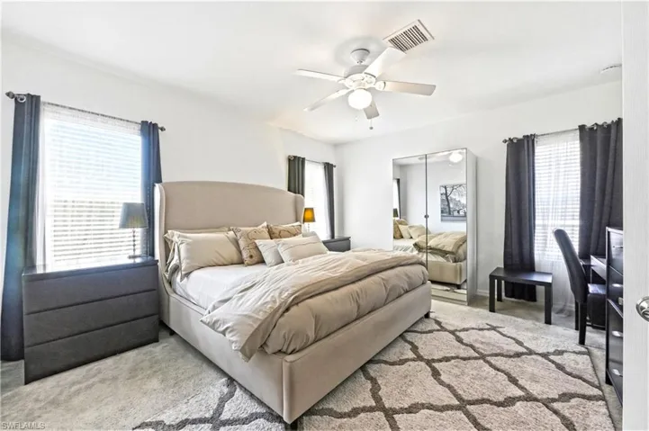 Primary bedroom with a king size bed, dresser, nightstands and TV