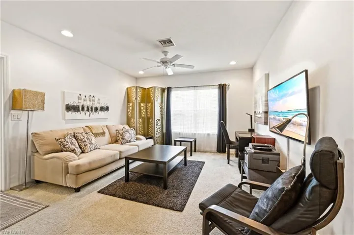 Loft with couch, coffee table, TV and desk with desk chair